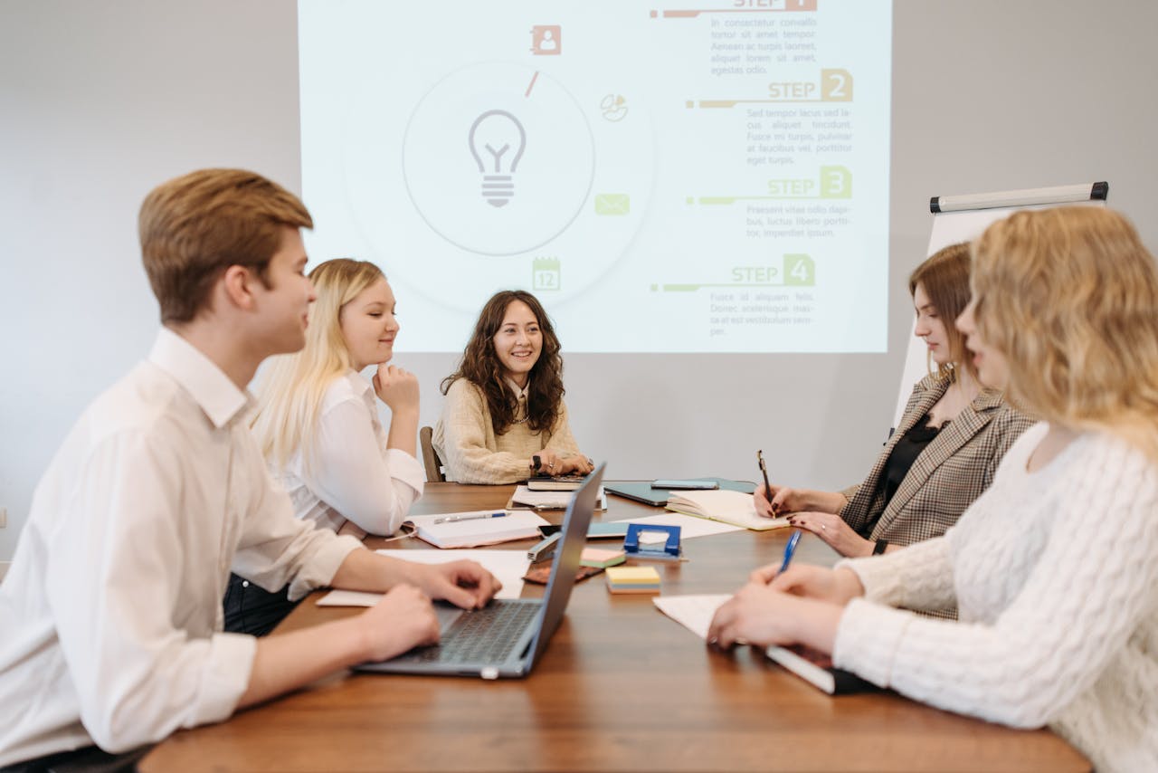 A diverse team of young professionals engaged in a collaborative meeting in an office setting.